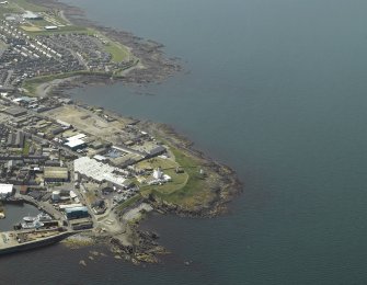 Oblique aerial view centred on the lighthouse and museum with the remains of the tower adjacent, taken from the E.