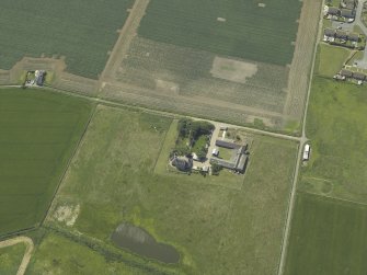 Oblique aerial view centred on the farmhouse and farmsteading, taken from the ENE.
