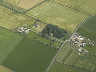 Oblique aerial view centred on the remains of the castle and tower-house, taken from the NW.