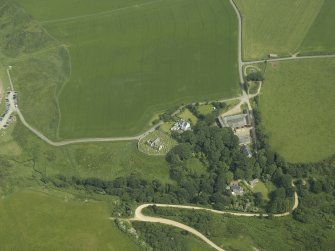 Oblique aerial view centred on the remains of the church and burial ground with the hotel and former manse adjacent, taken from the WNW.