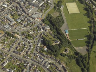 Oblique aerial view centred on the remains of the church and the burial-ground, taken from the NW.