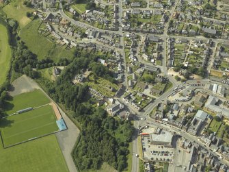 Oblique aerial view centred on the remains of the church and the burial-ground, taken from the SE.