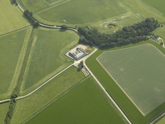 Oblique aerial view centred on the remains of the castle and the farmsteading, taken from the NE.