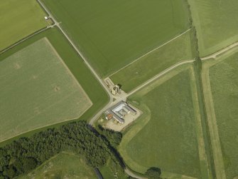 Oblique aerial view centred on the remains of the castle and the farmsteading, taken from the SW.