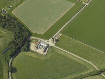 Oblique aerial view centred on the remains of the castle and the farmsteading, taken from the SSE.