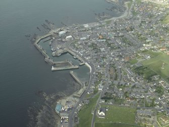 General oblique aerial view of the town, centred on the church and the harbour, taken from the SW.