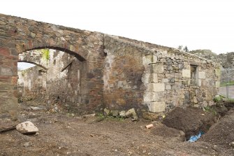 Arched pend and outbuilding to S, view from NW