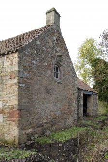 Building to SE of steading, S gable, view from SW showing the reused stonework.
