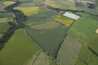 General oblique aerial view centred on the cropmarks of the unenclosed settlement, pits, rig, possible enclosure, the linear cropmarks and frost wedges with the farmhouse and farmsteading adjacent, taken from the N.