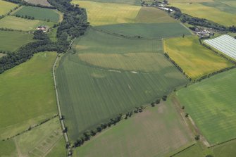 General oblique aerial view centred on the cropmarks of the unenclosed settlement, pits, rig, possible enclosure, the linear cropmarks and frost wedges with the farmhouse and farmsteading adjacent, taken from the NNW.