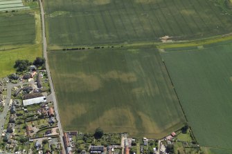 Oblique aerial view centred on the cropmarks of the enclosure and rig, taken from the NNW.