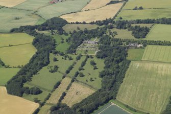 General oblique aerial view centred on the country house, gardens, stables, farmsteading and gate-lodge, taken from the SE.