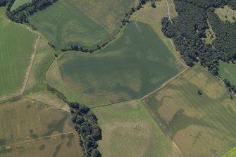 Oblique aerial view centred on the cropmarks of the ring-ditches, enclosures and rig and the linear cropmarks with the cropmarks of the pits adjacent, taken from the E.