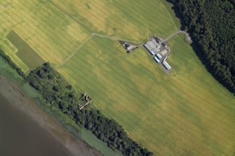 Oblique aerial view centred on the cropmarks of the enclosures and field boundaries with the farmhouse, farmsteading and remains of the castle adjacent, taken from the NW.