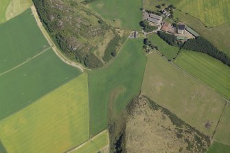 Oblique aerial view centred on the parchmarks of the enclosure with the farmsteading, tower-house and remains of the church adjacent, taken from the W.