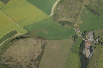 Oblique aerial view centred on the parchmarks of the enclosure with the farmsteading, tower-house and remains of the church and fort adjacent, taken from the SW.