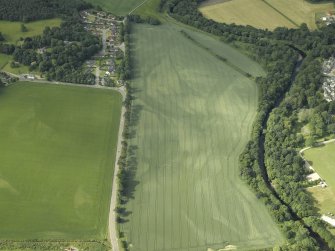 Oblique aerial view centred on the cropmarks of the rig, pits and possible souterrain and the field boundaries with the gate-lodge adjacent, taken from the NNE.