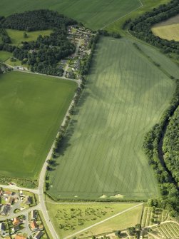 Oblique aerial view centred on the cropmarks of the rig, pits and possible souterrain and the field boundaries with the gate-lodge adjacent, taken from the N.