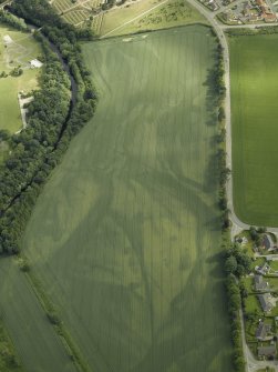 Oblique aerial view centred on the cropmarks of the rig, pits and possible souterrain and the field boundaries with the gate-lodge adjacent, taken from the SSW.