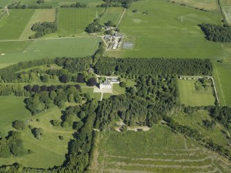 Oblique aerial view centred on the castle, country house and walled garden with the sawmill adjacent, taken from the SE.
