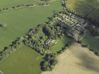 Oblique aerial view centred on the country house with the farmhouse, farmsteading and cottage adjacent, taken from the SSE.