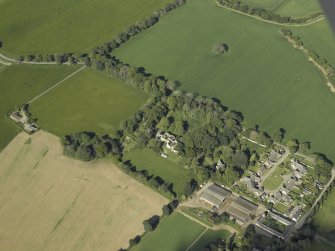 Oblique aerial view centred on the country house with the farmhouse, farmsteading and cottage adjacent, taken from the E.