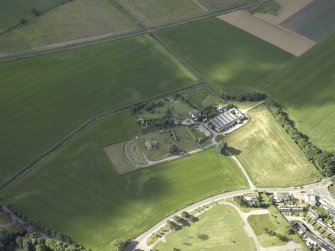 General oblique aerial view centred on the remains of the abbey and burial-ground and the farmsteading, taken from the N.