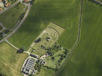 Oblique aerial view centred on the remains of the abbey and burial-ground and the farmsteading, taken from the SW.