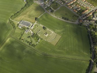 General oblique aerial view centred on the remains of the abbey and burial-ground and the farmsteading, taken from the SE.