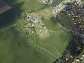 General oblique aerial view centred on the remains of the abbey and burial-ground and the farmsteading, taken from the E.