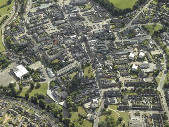 Oblique aerial view centred on the church and burial ground, taken from the W.