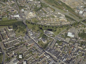 Oblique aerial view centred on the church and burial ground, taken from the E.