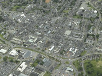 General oblique aerial view of the town centred on the church, taken from the NW.