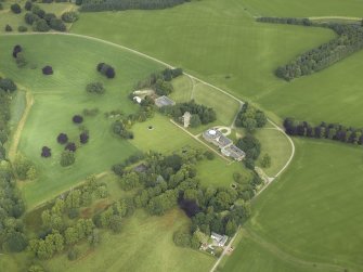 Oblique aerial view centred on the country house, tower-house, farmhouse, farmsteading, cottages and stables, taken from the ESE.