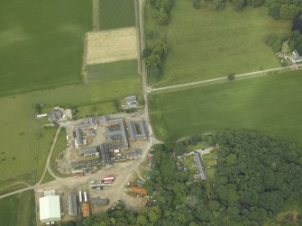 Oblique aerial view centred on the farmsteading, farmhouse and kennels, taken from the ENE.