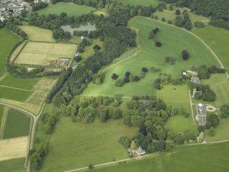 General oblique aerial view centred on the country house, tower-house, farmhouse, farmsteading, cottages and stables with the walled garden adjacent, taken from the E.