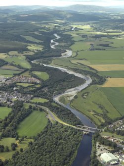 General oblique aerial view looking along the River Spey with the road bridges in the foreground, taken from the NE.