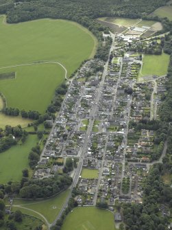 Oblique aerial view of the town centred on the church, chapel and parsonage, taken from the WNW.