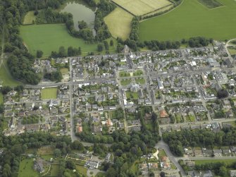 Oblique aerial view of the town centred on the church, chapel and parsonage, taken from the SW.