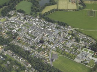 Oblique aerial view of the town centred on the church, school, chapel and parsonage, taken from the S.