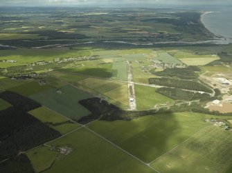 General oblique aerial view centred on the airfield with the villages in the distance, taken from the E.