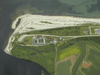 Oblique aerial view centred on the fishing station, ice-house, farmhouse and farmsteading, taken from the SSW.