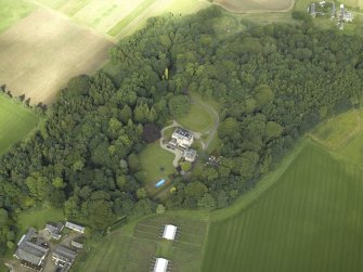 Oblique aerial view centred on the country house with the farmhouse and farmsteading adjacent, taken from the ESE.