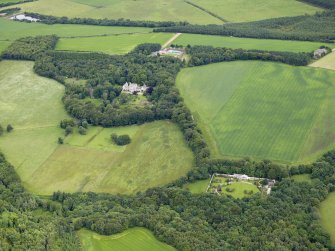 General oblique aerial view centred on the country house with the farmhouse, farmsteading and granary in the distance and the walled garden and cottage in the foreground, taken from the SW.