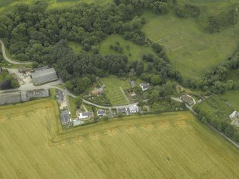 Oblique aerial view centred on the remains of the church, burial ground and tower-house, taken from the NW.