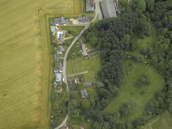Oblique aerial view centred on the remains of the church, burial ground and tower-house, taken from the SW.