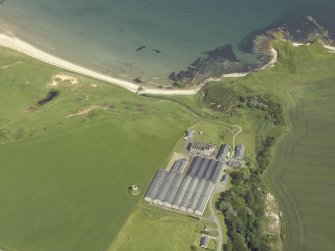 Oblique aerial view centred on the whisky distillery with the remains of the windmill adjacent, taken from the SSE.