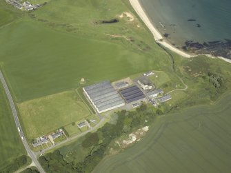 Oblique aerial view centred on the whisky distillery with the remains of the windmill adjacent, taken from the ESE.