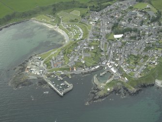Oblique aerial view of the village centred on the harbours, taken from the NW.
