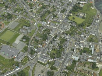 Oblique aerial view centred on the church with the school adjacent, taken from the SE.